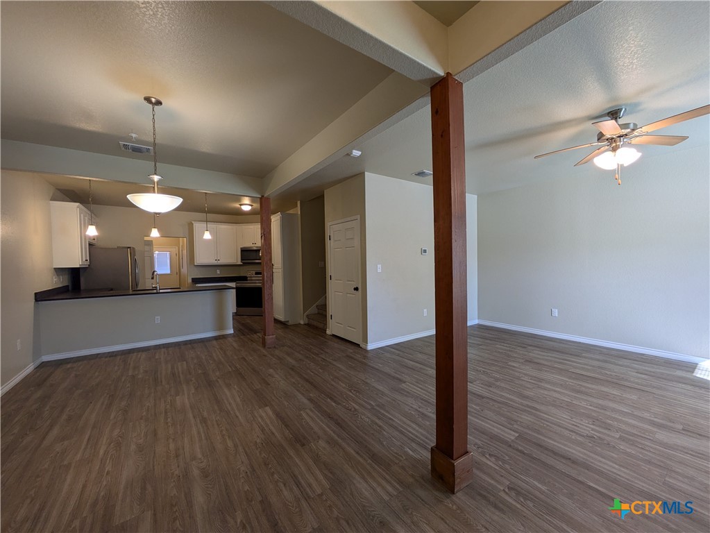 a view of a room with a ceiling fan window and wooden floor