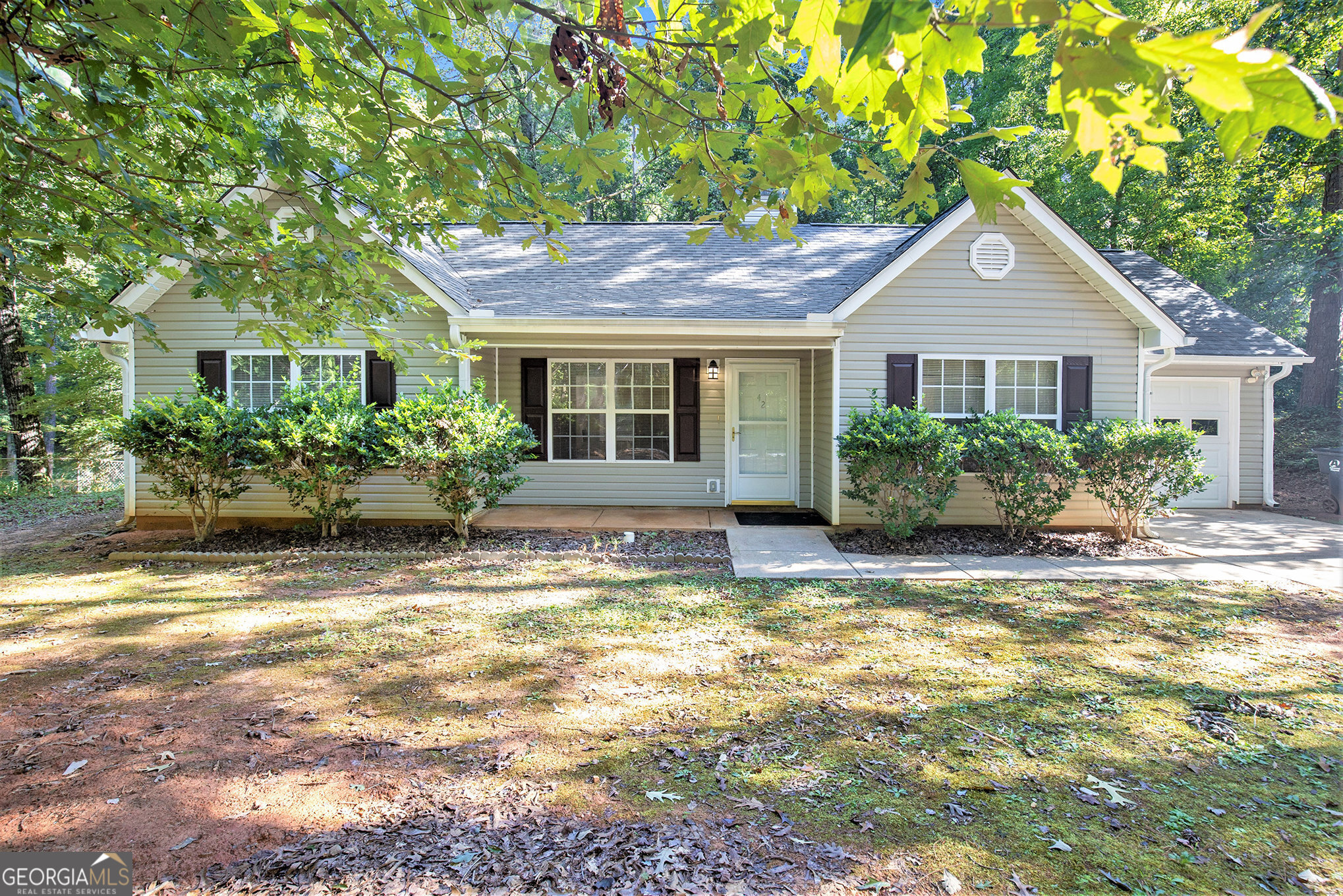 a front view of a house with a yard and potted plants