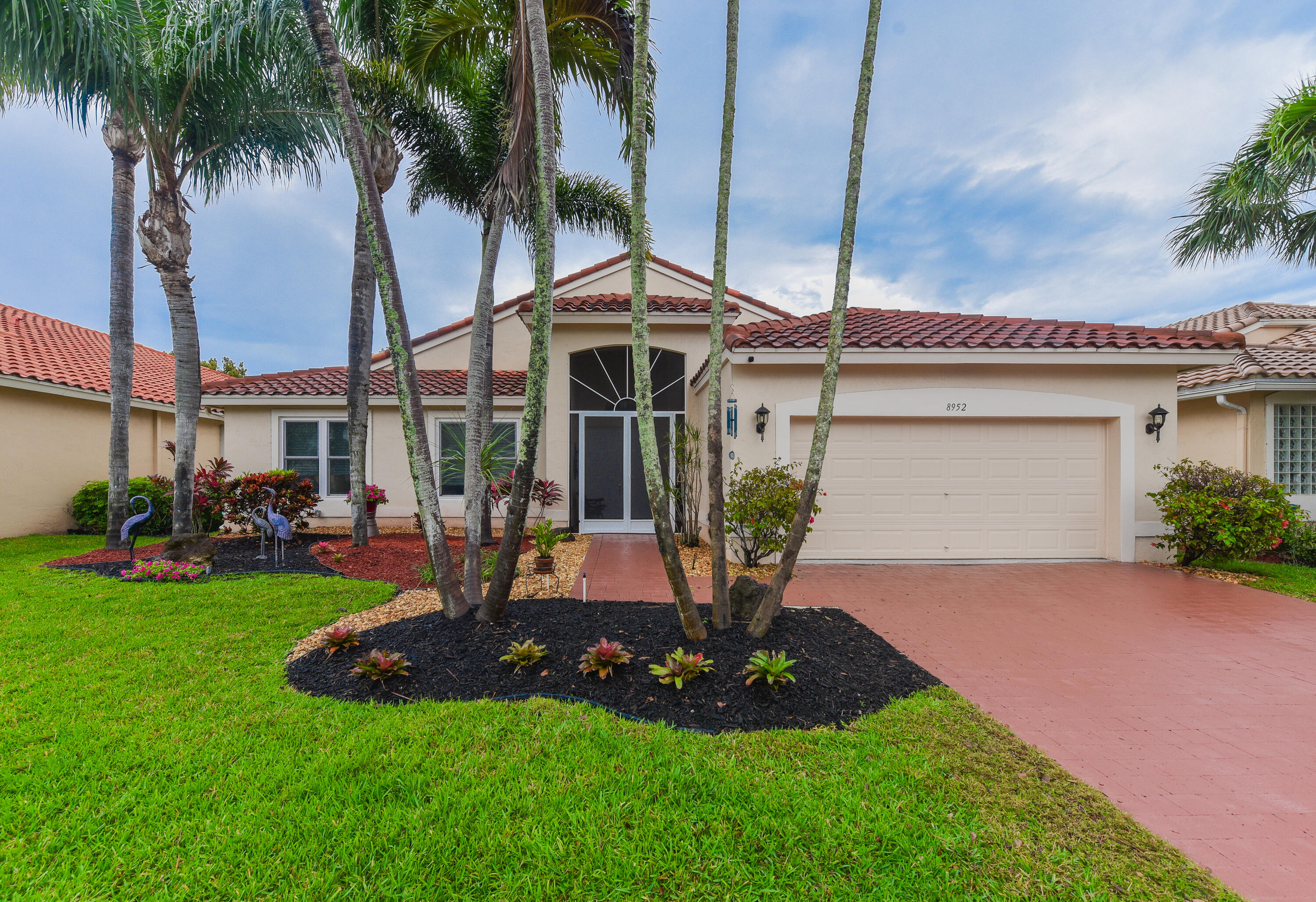 a front view of a house with garden and patio