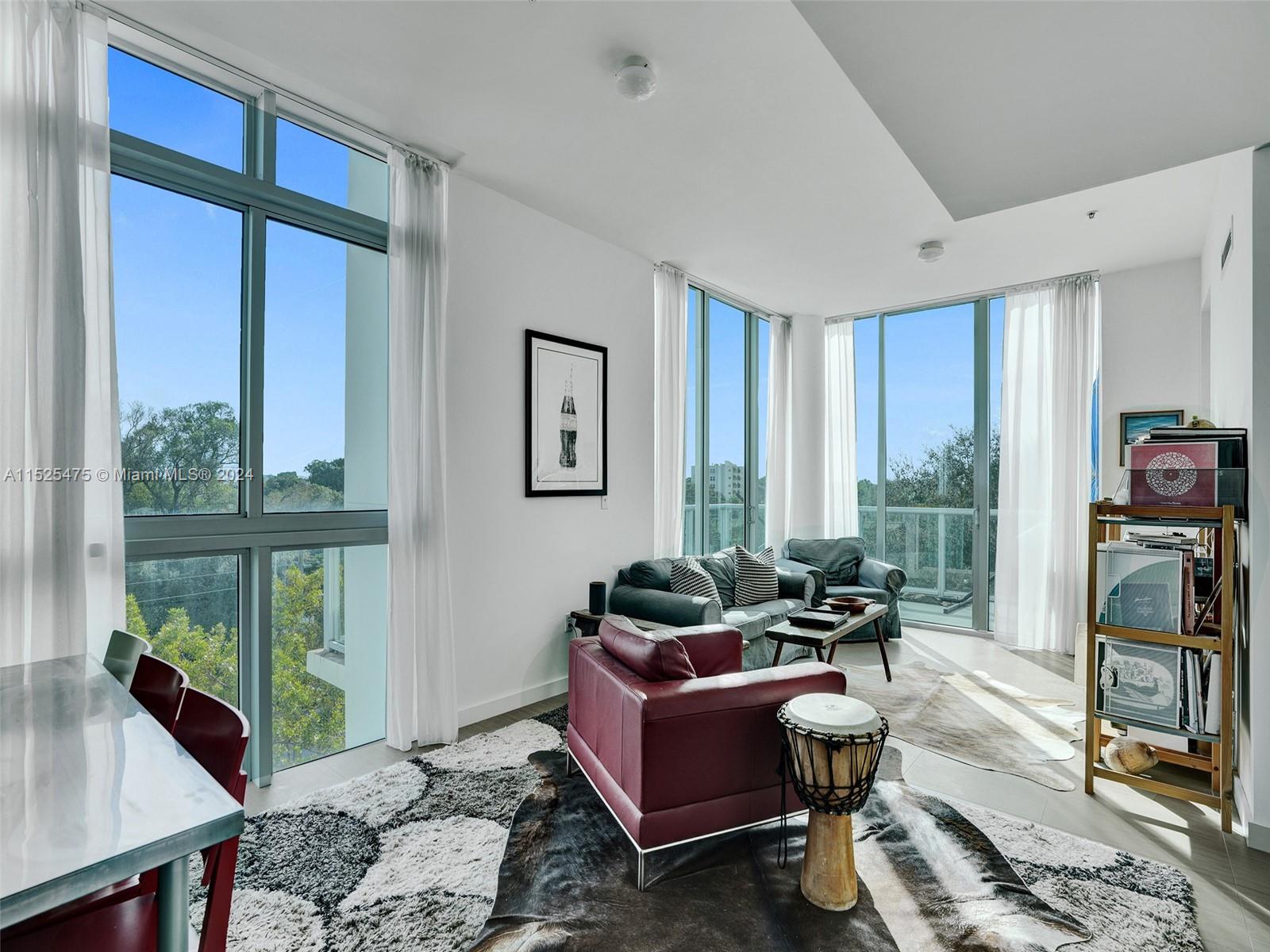 a living room with furniture a large window and a flat screen tv