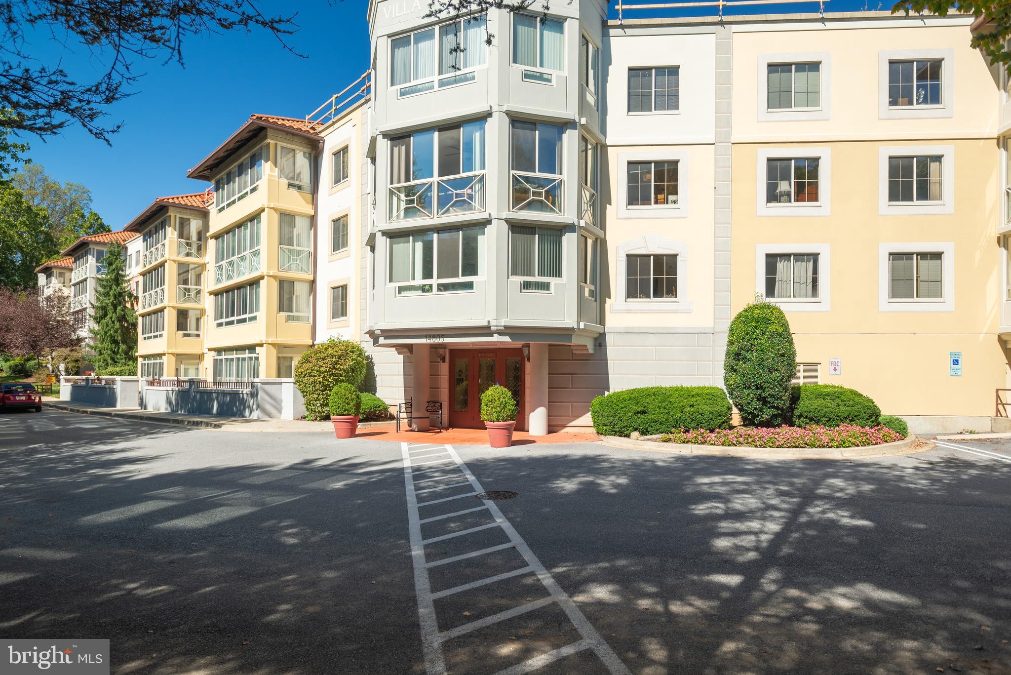 a front view of a building with outdoor space and a car parked