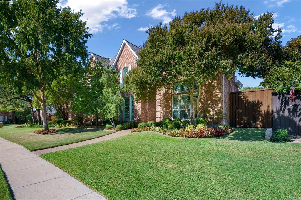 a view of a house with a big yard and large trees