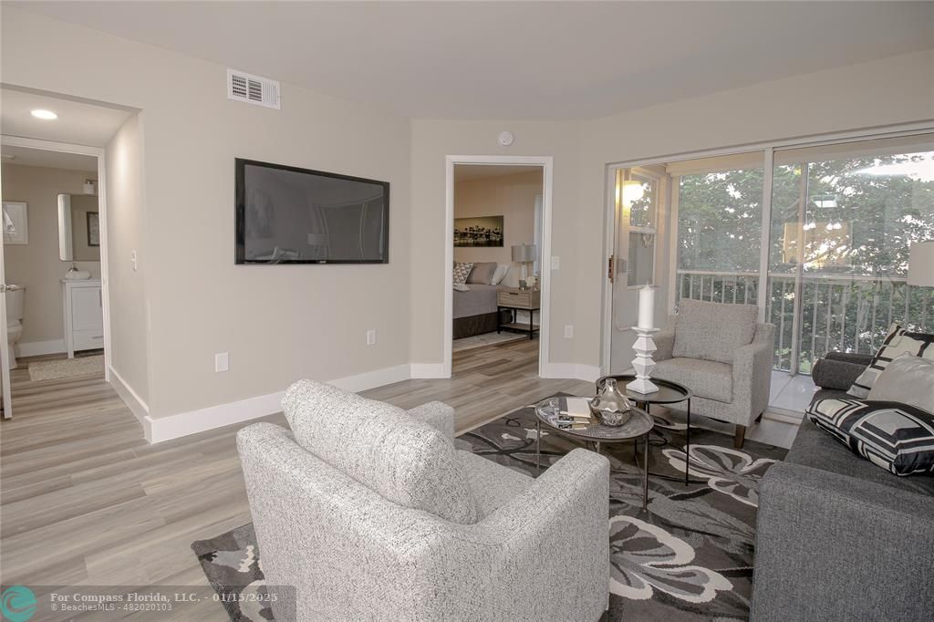 a living room with furniture and a floor to ceiling window