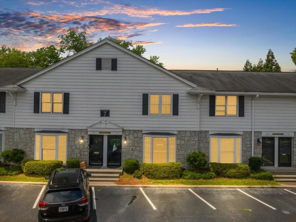 a front view of a house with yard and parking