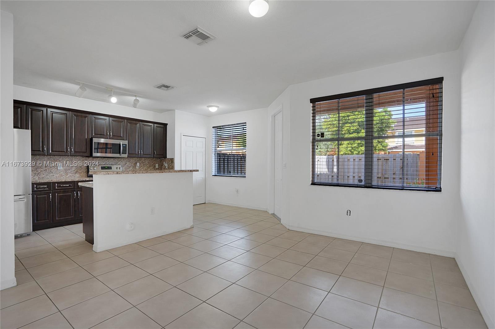 a view of kitchen with stainless steel appliances granite countertop a stove top oven a sink dishwasher and a refrigerator