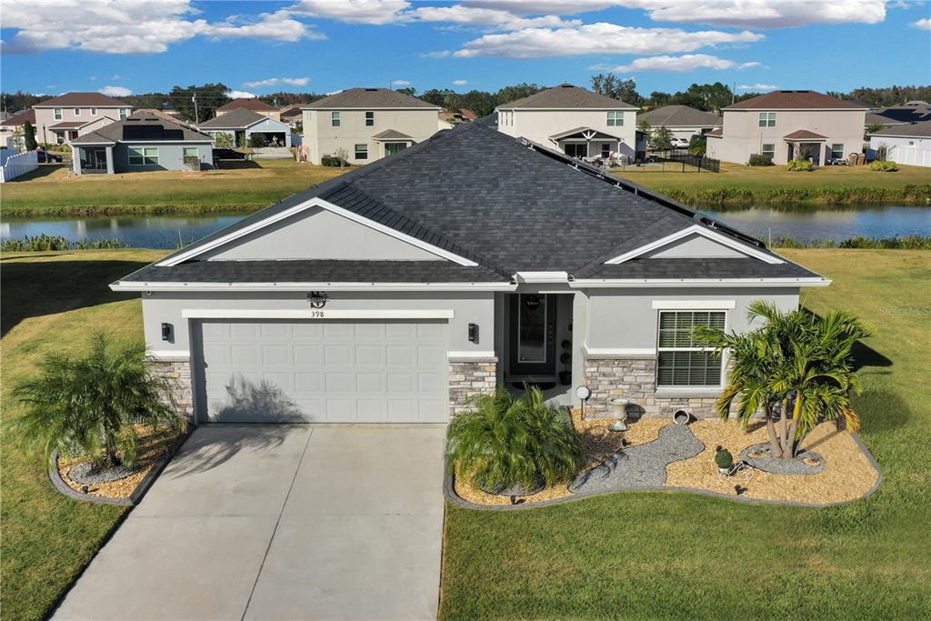 an aerial view of a house with a yard and potted plants