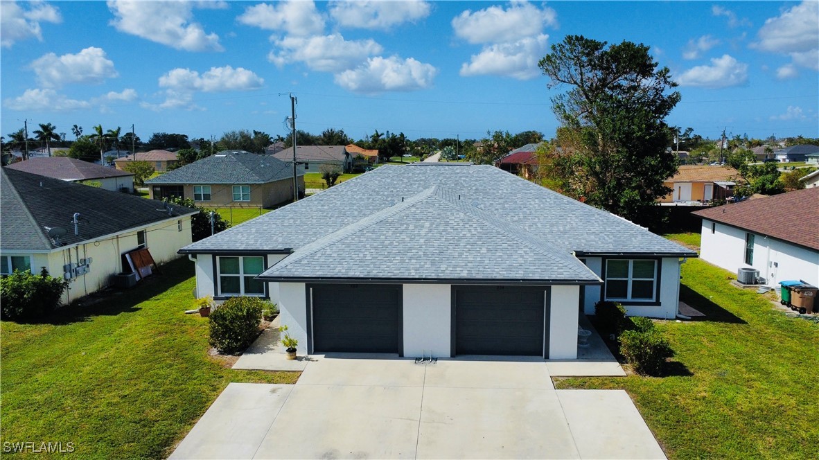 a front view of house with yard and trees in the background