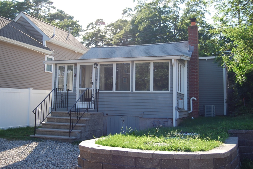 a view of a house with a small yard and flower wooden fence