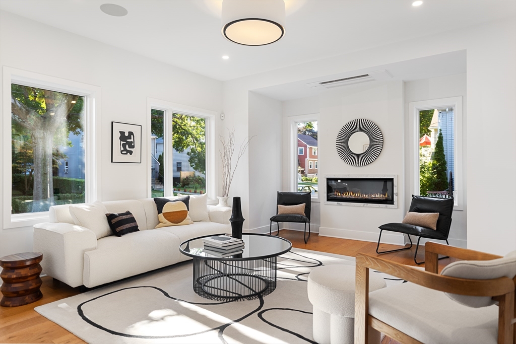 a living room with fireplace furniture and a large window