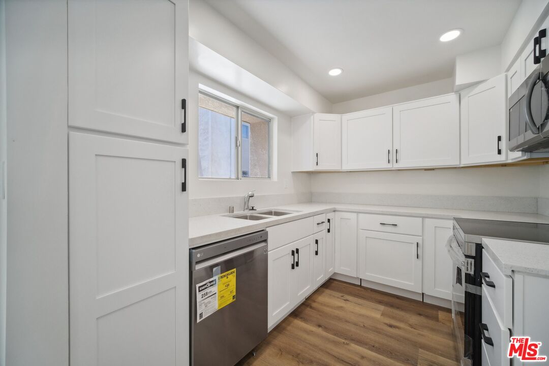 a kitchen with granite countertop cabinets stainless steel appliances and a sink