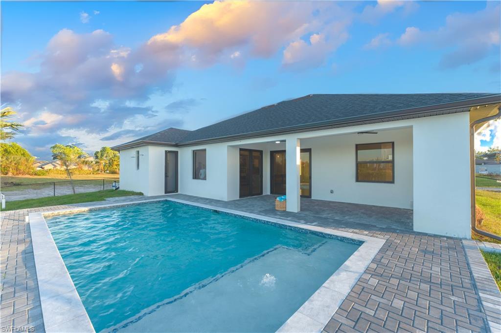 View of swimming pool with ceiling fan and a patio