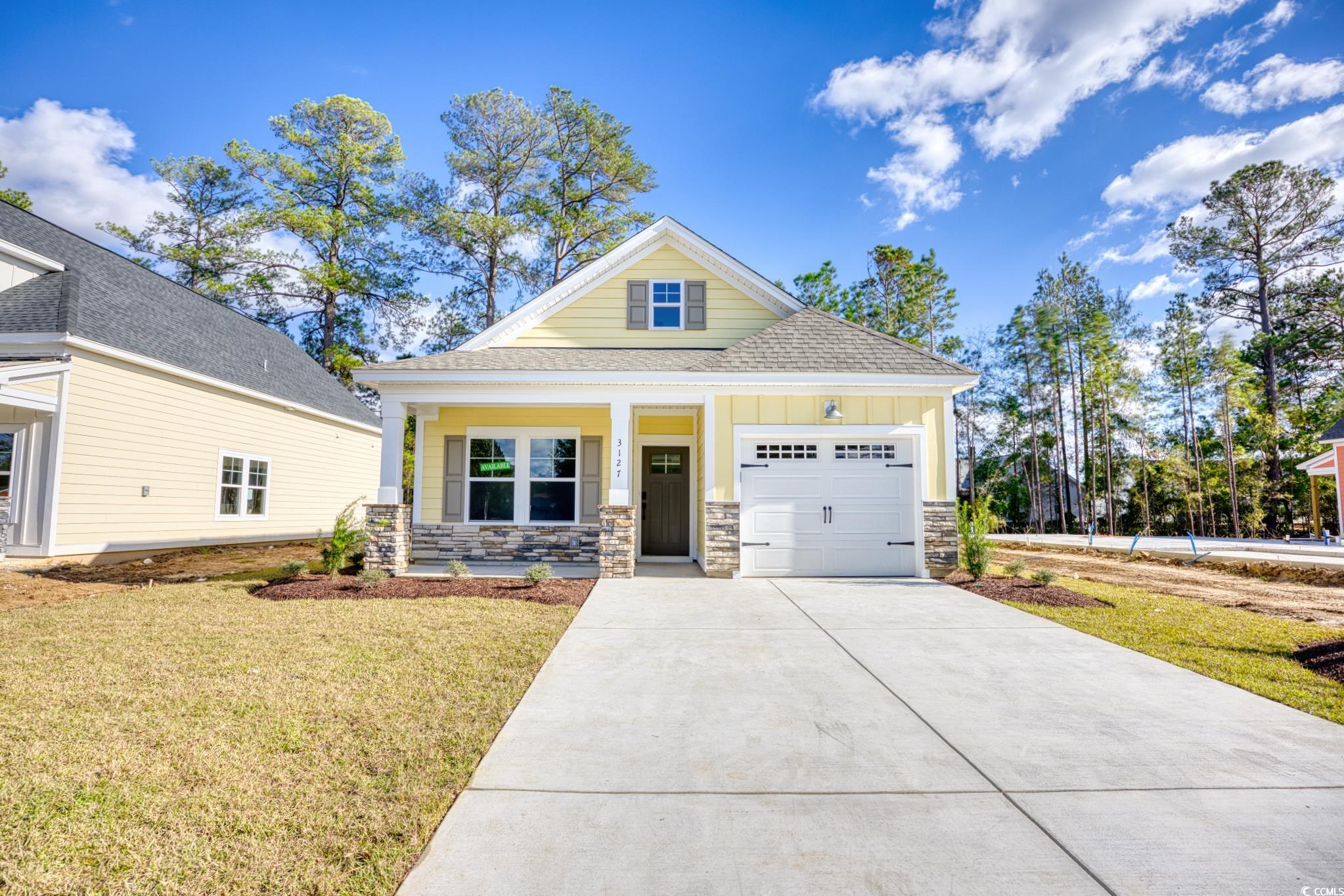 View of front facade with a front yard, a garage,