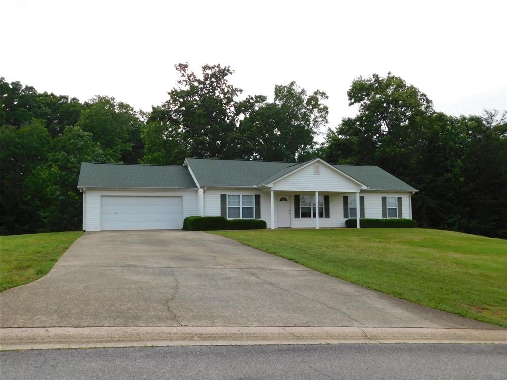 a front view of a house with a yard and trees