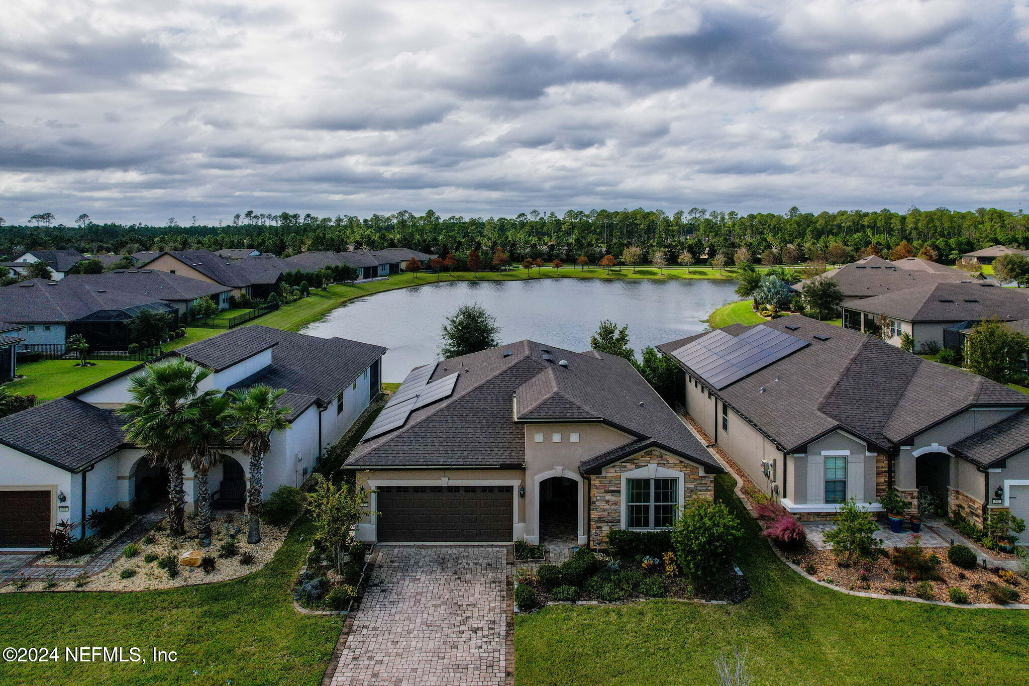 an aerial view of a house with garden space and lake view in back