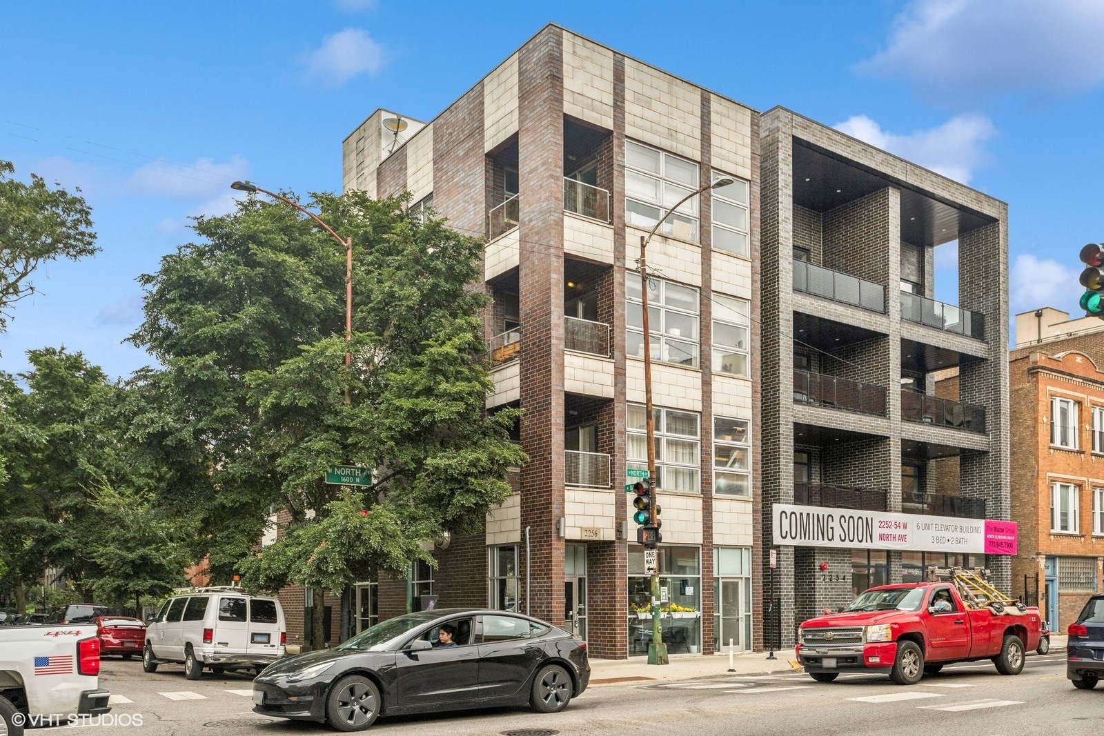 a view of building with cars parked across