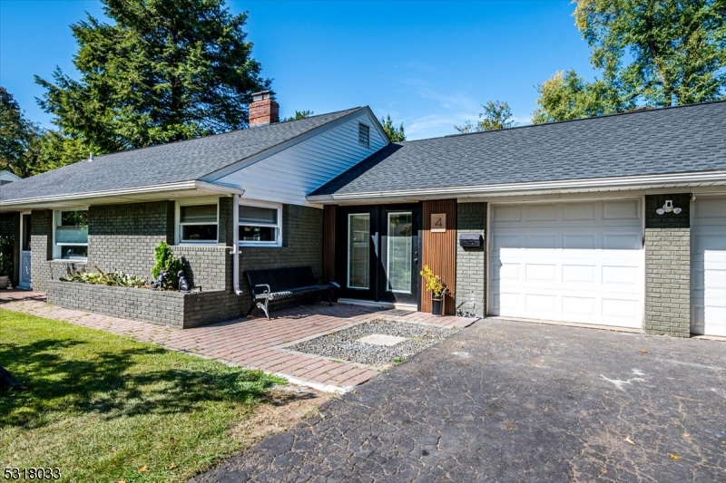 a front view of a house with a yard and potted plants