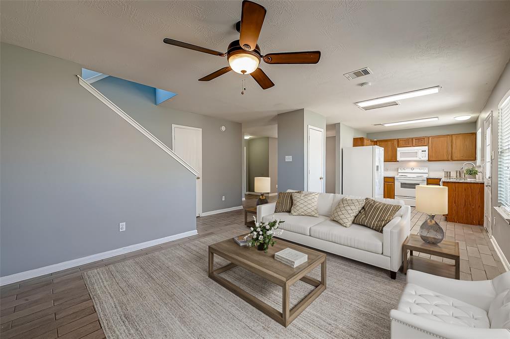 a living room with furniture and a view of kitchen