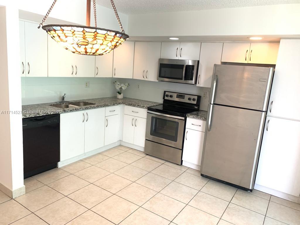 a kitchen with a sink a microwave and refrigerator