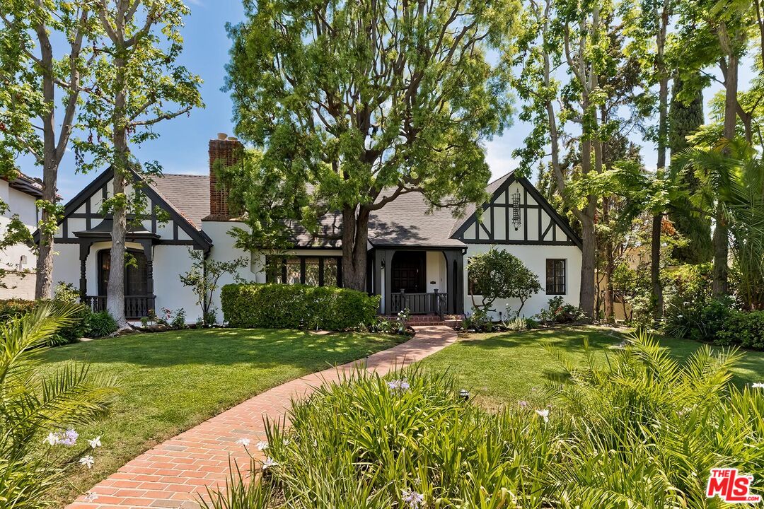 a front view of a house with a yard and trees