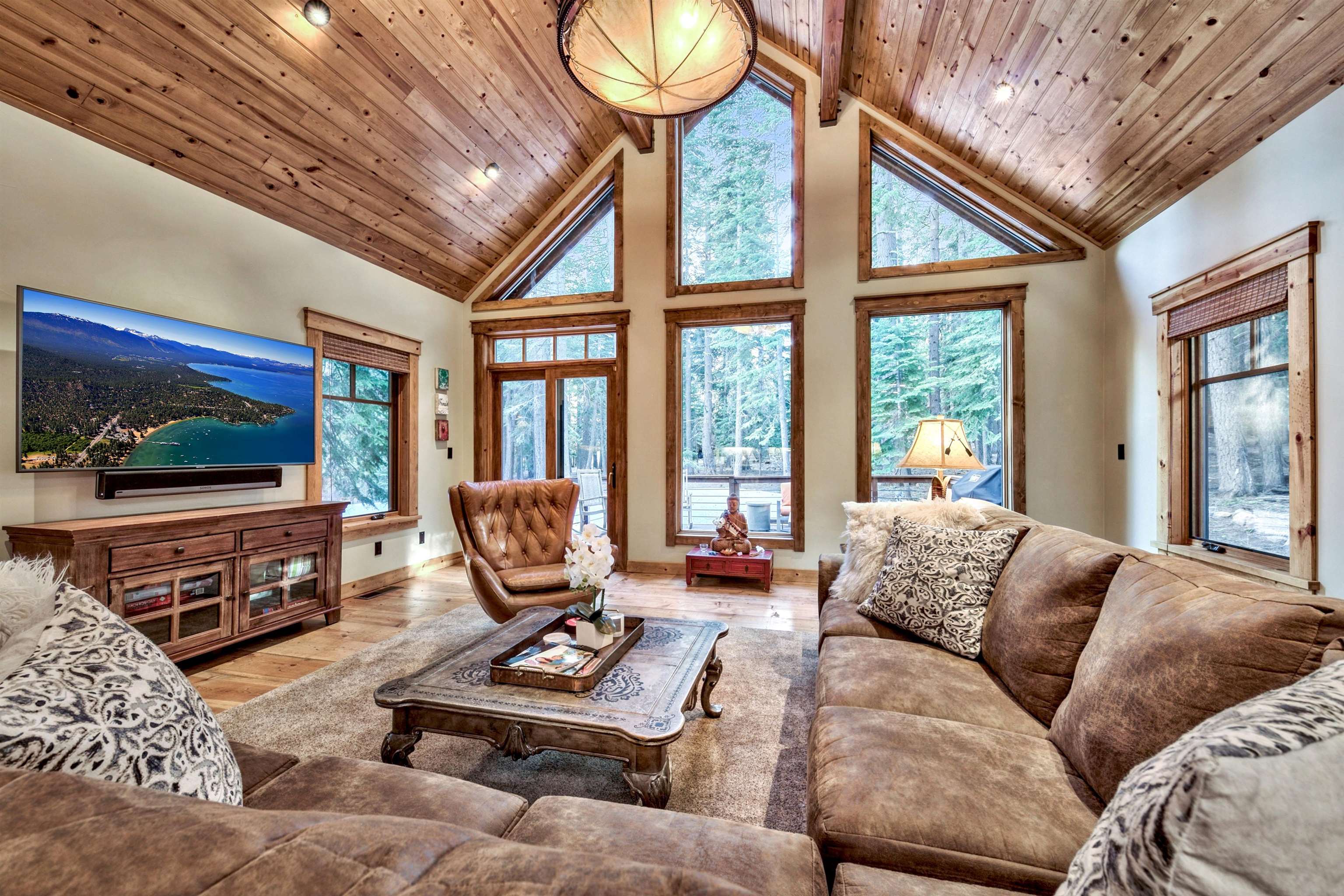 a living room with furniture a flat screen tv and a floor to ceiling window