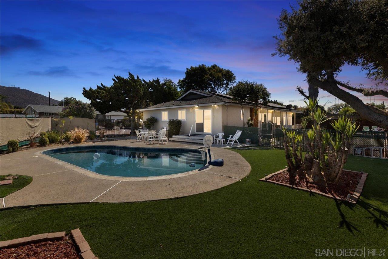 a view of a house with swimming pool and a yard