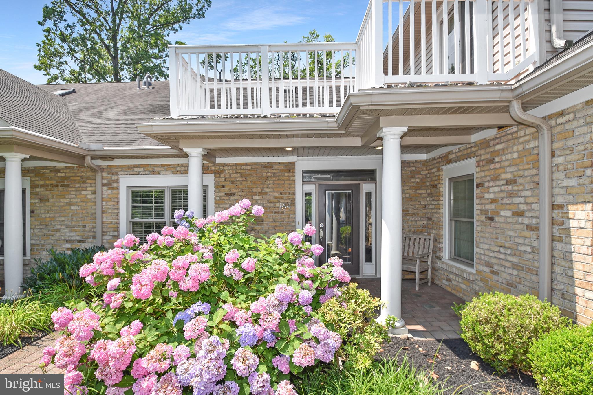 a front view of a house with a lot of flowers