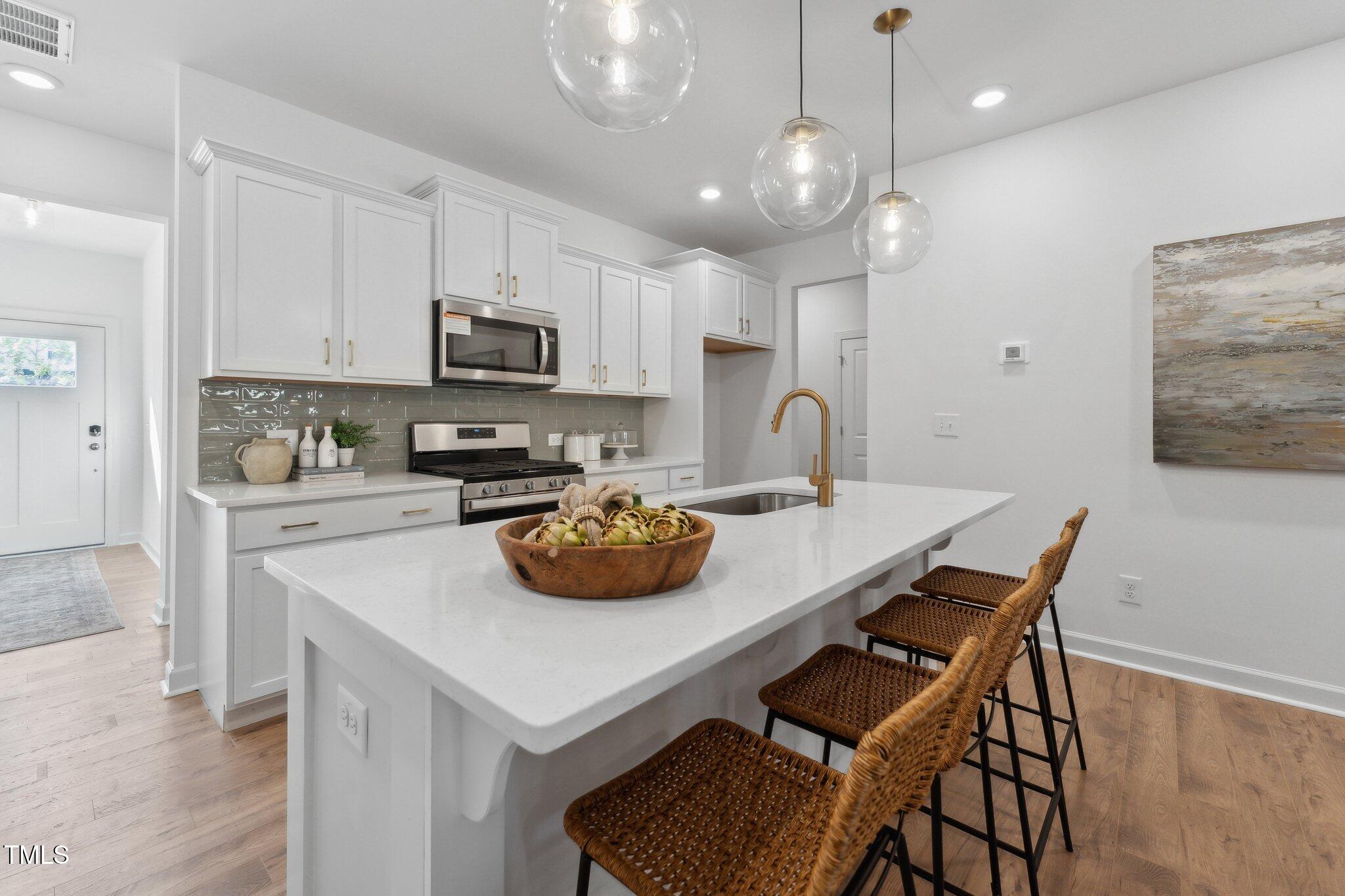 a kitchen with a sink a stove and chairs