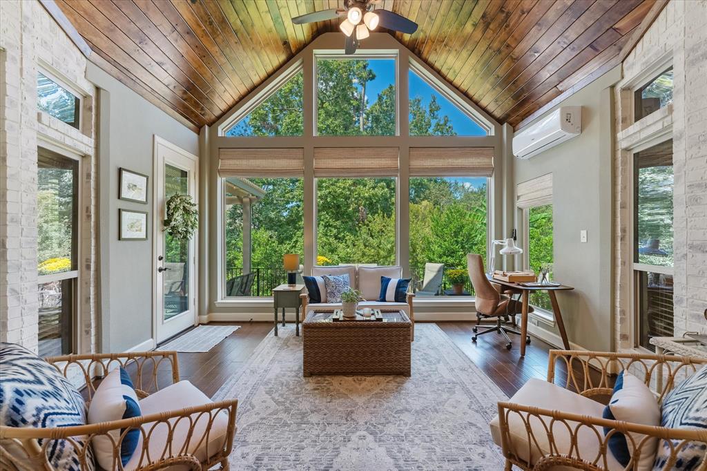 This lovely sunroom features soaring cathedral ceilings and beautiful wood flooring, creating a spacious and inviting atmosphere.