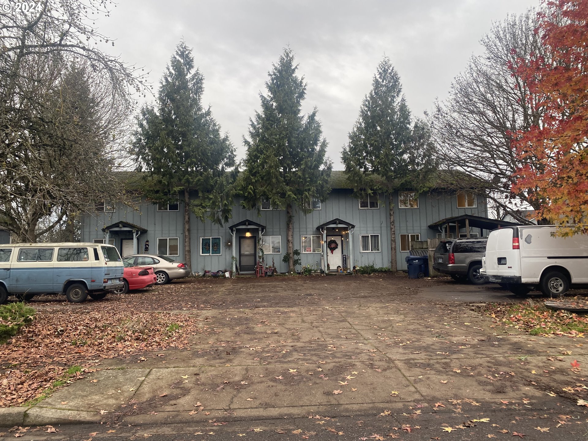 a front view of a house with cars parked