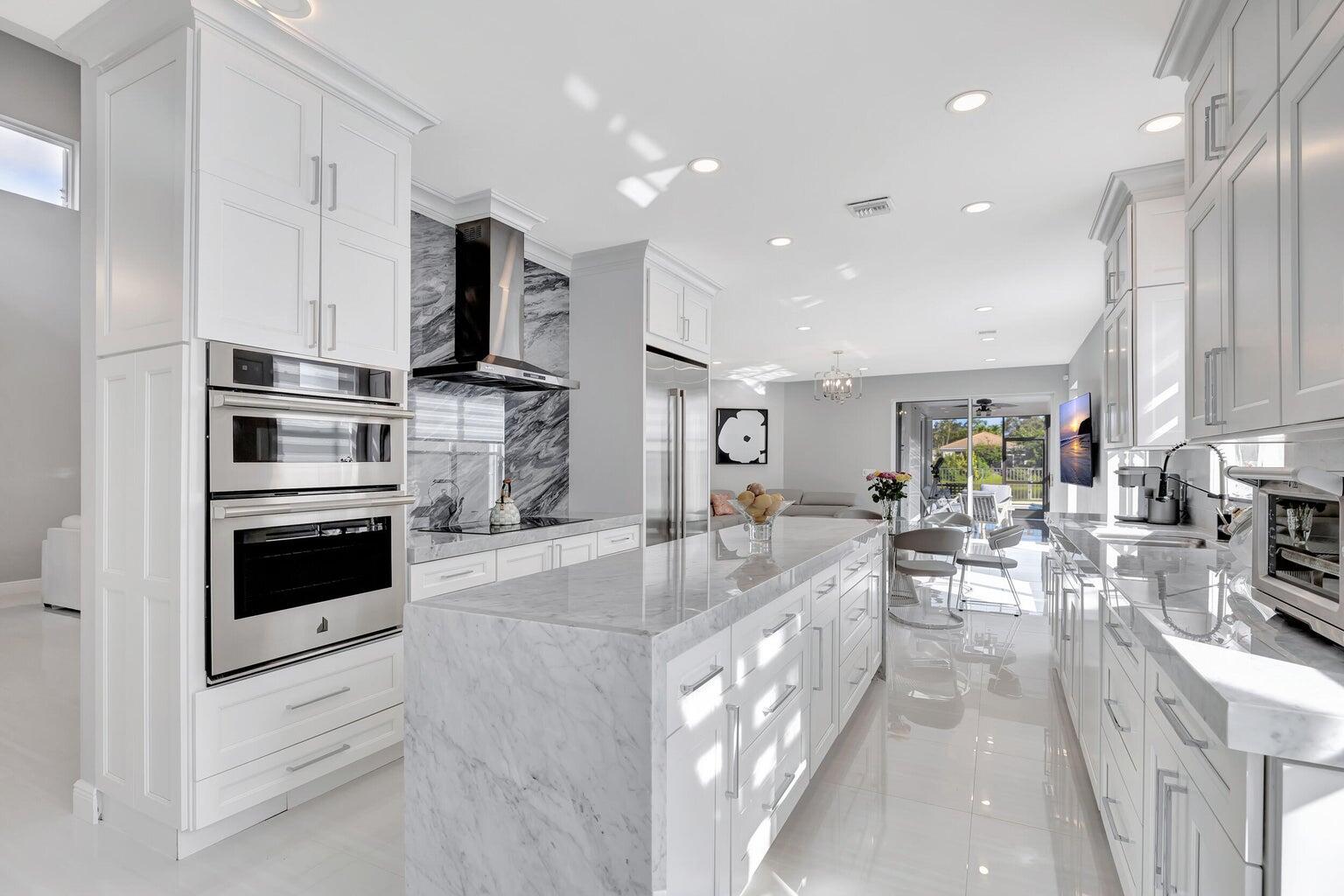 a large white kitchen with stainless steel appliances