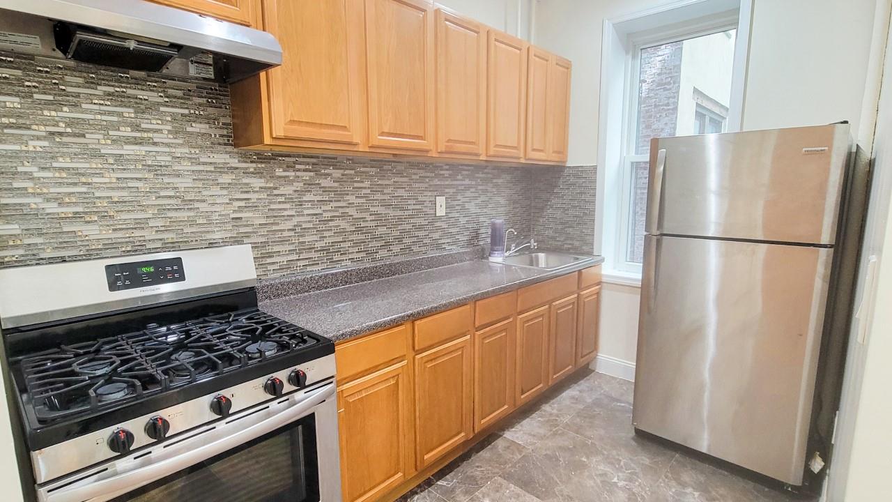 a kitchen with stainless steel appliances granite countertop a refrigerator stove and sink