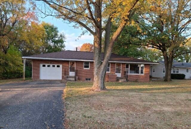 front view of a house with a large trees and a big yard