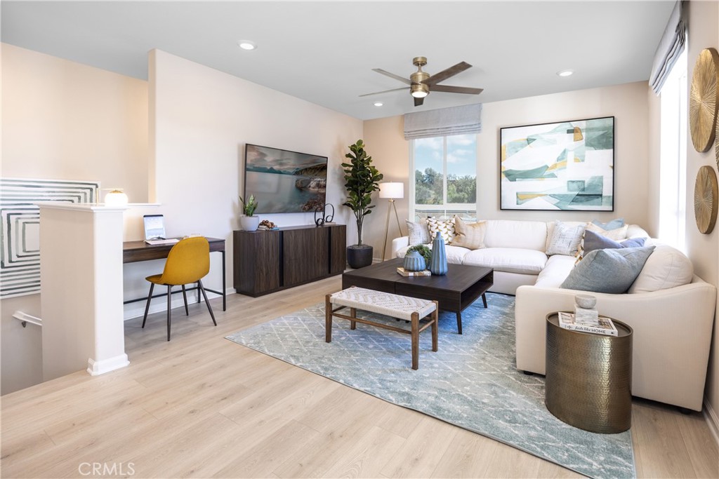 a living room with furniture a ceiling fan and a window