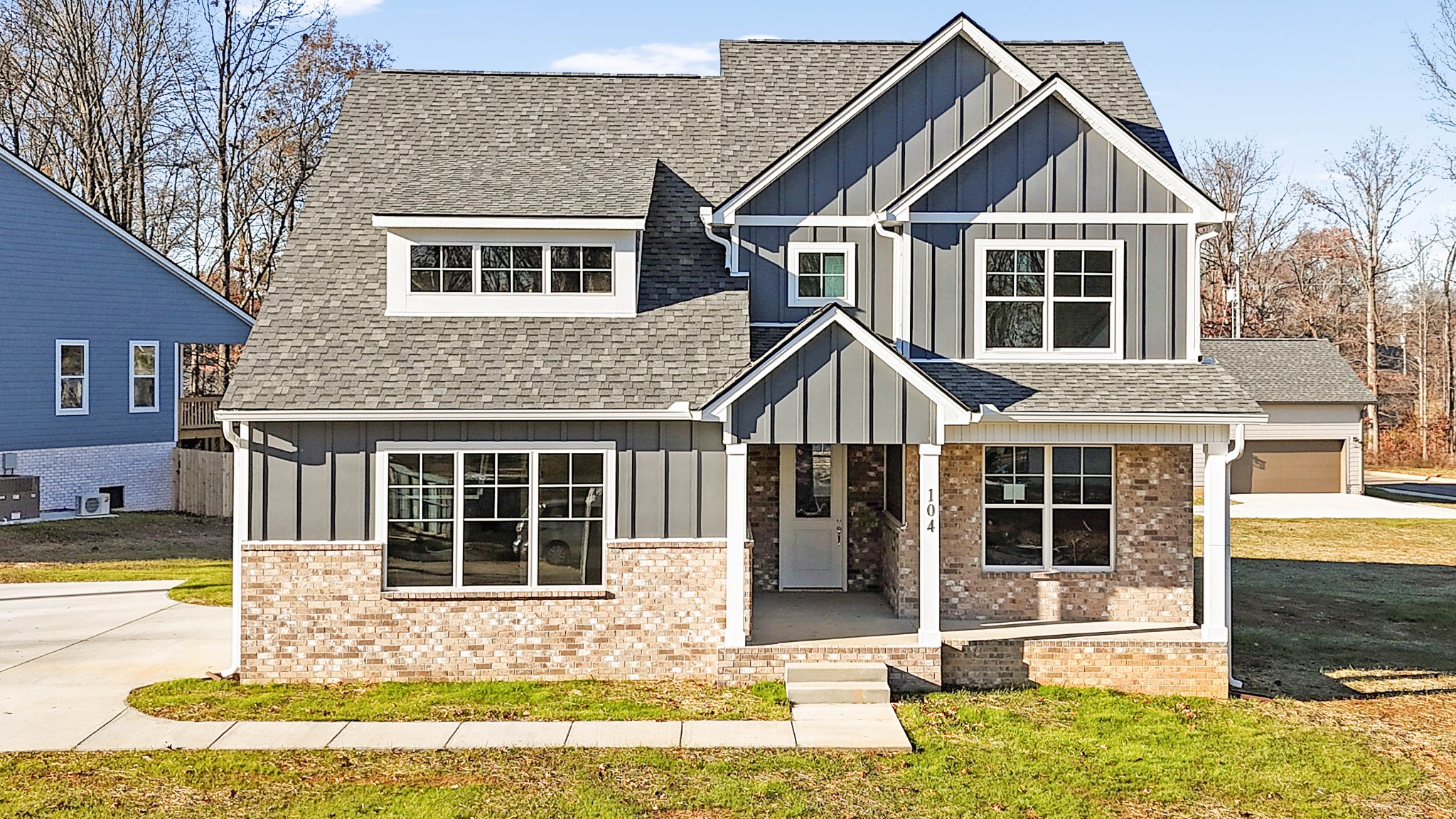 a front view of a house with a yard outdoor seating and garage