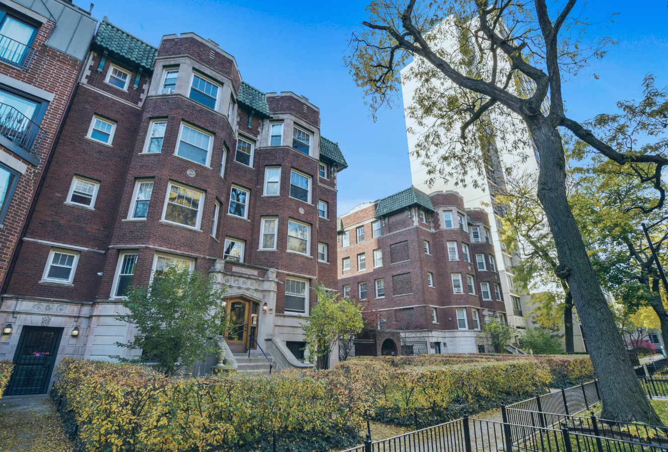 a view of a building next to a large tree