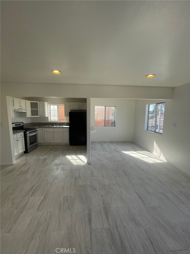 an empty room with windows and fireplace