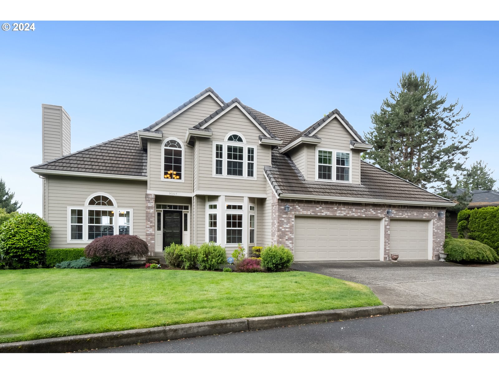 a front view of a house with a yard and garage