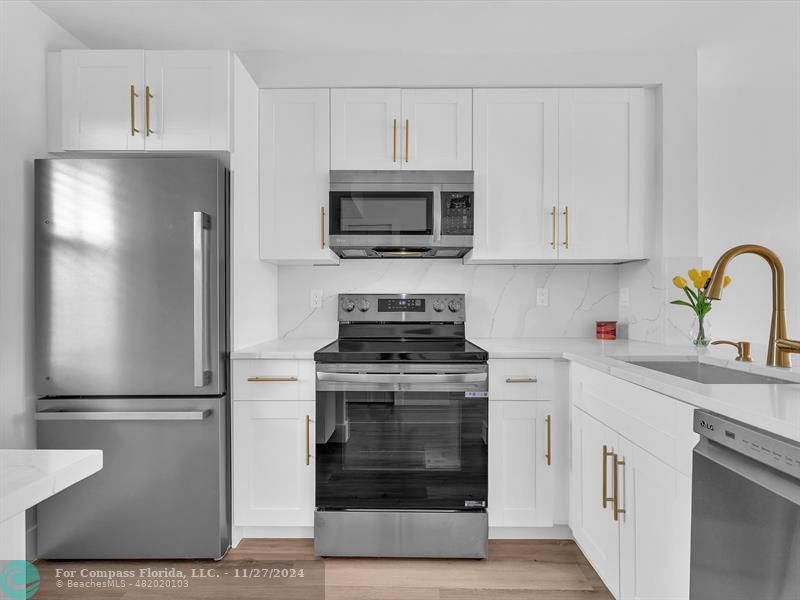 a kitchen with cabinets stainless steel appliances and a sink