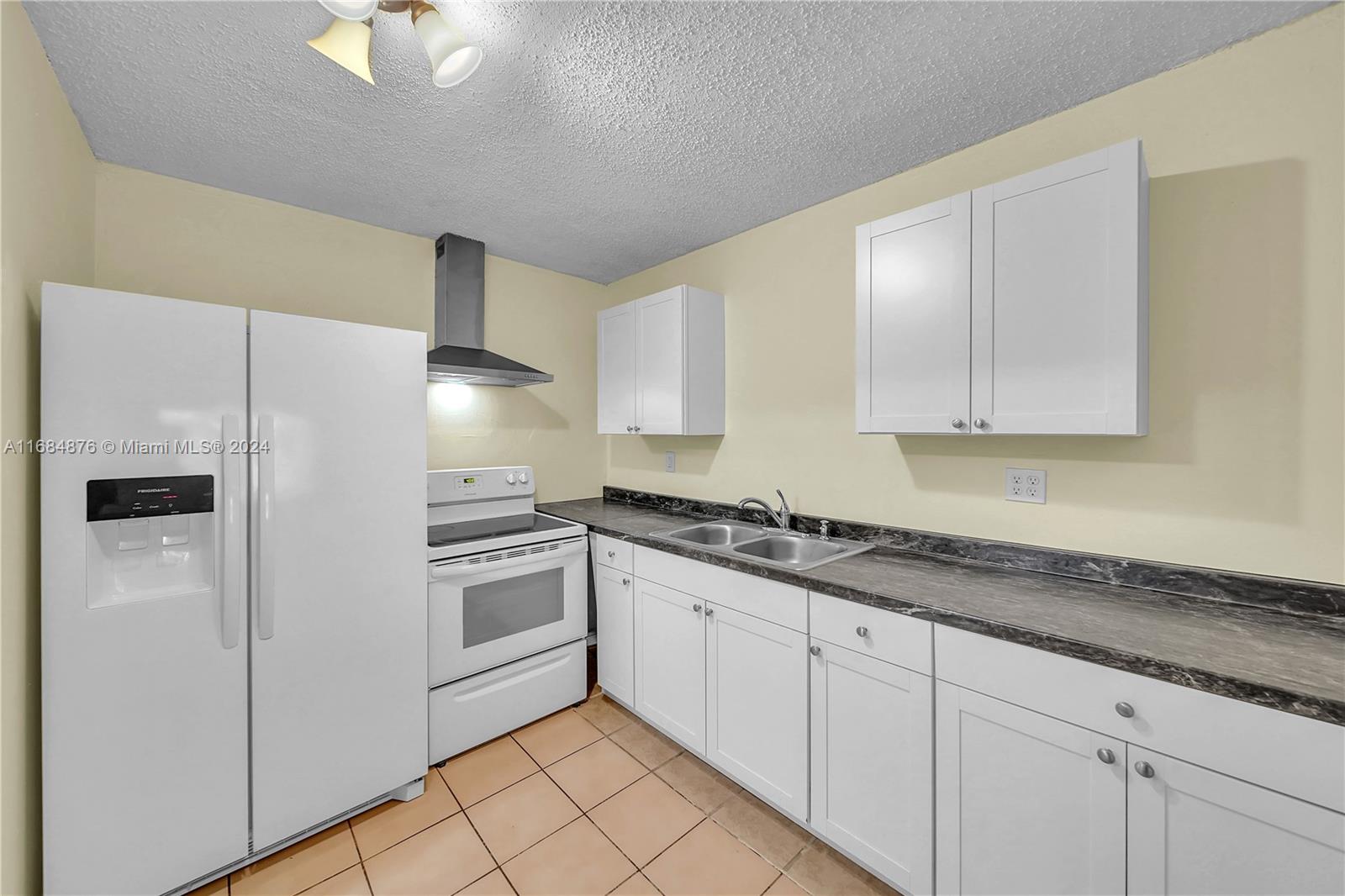 a kitchen with a sink a refrigerator and cabinets