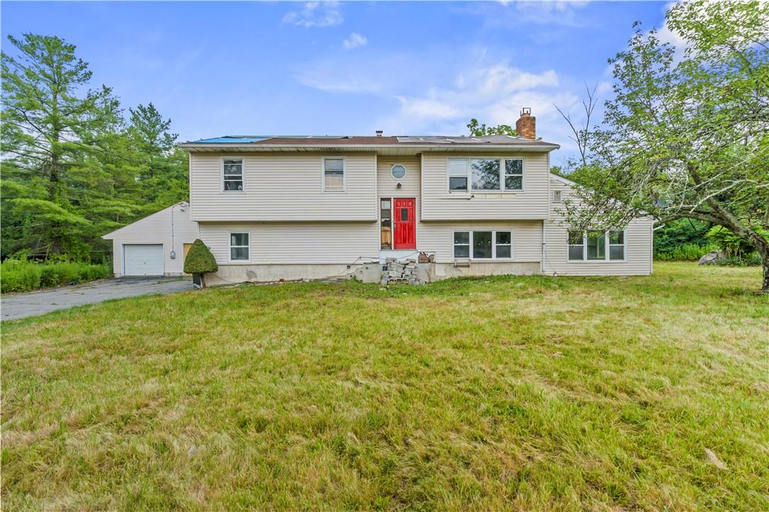 Raised ranch with a garage and a front yard