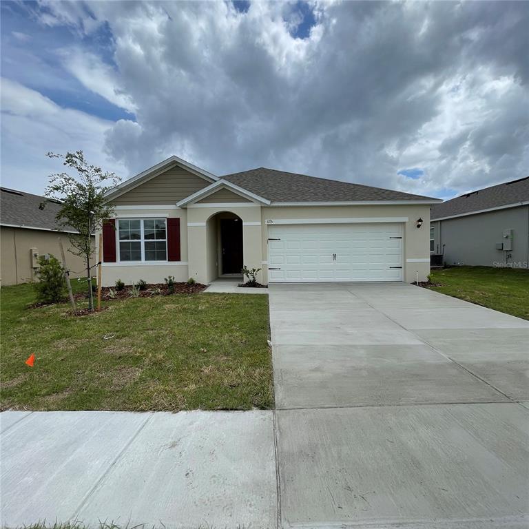 a front view of a house with a garden and yard