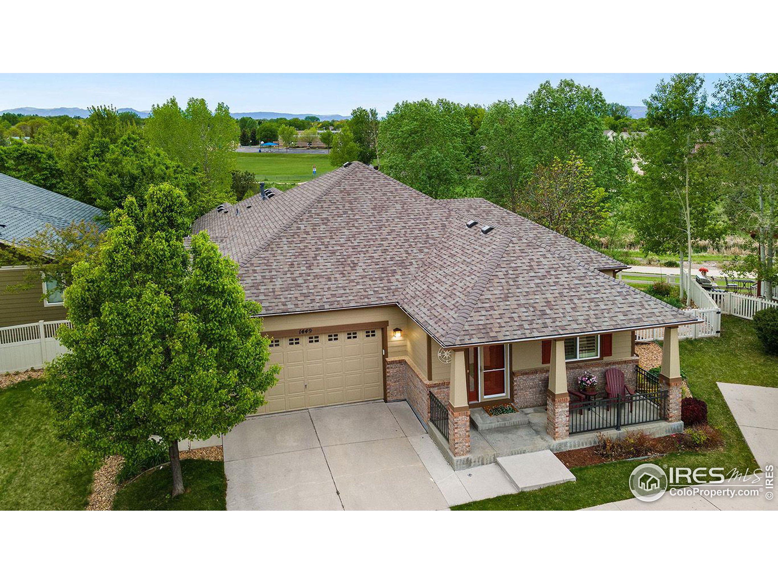 a aerial view of a house with a yard plants and large tree