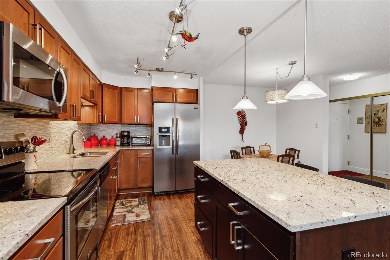 a kitchen with stainless steel appliances granite countertop a sink and a refrigerator