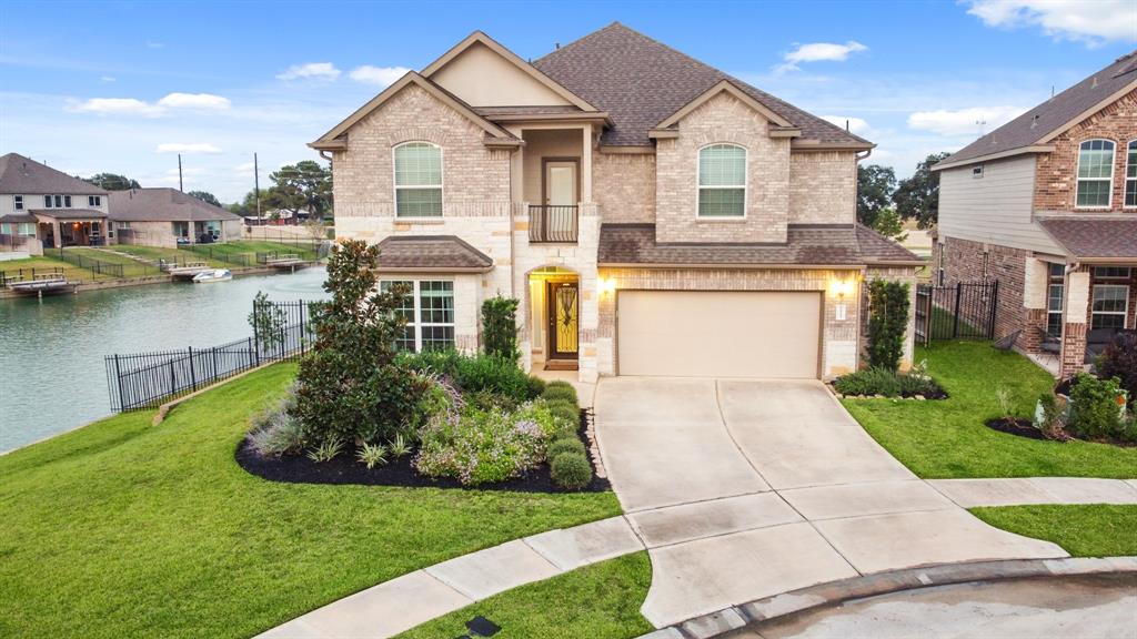 a front view of a house with a yard and lake view