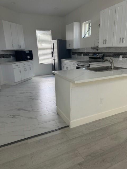 a kitchen with stainless steel appliances granite countertop a sink stove and cabinets