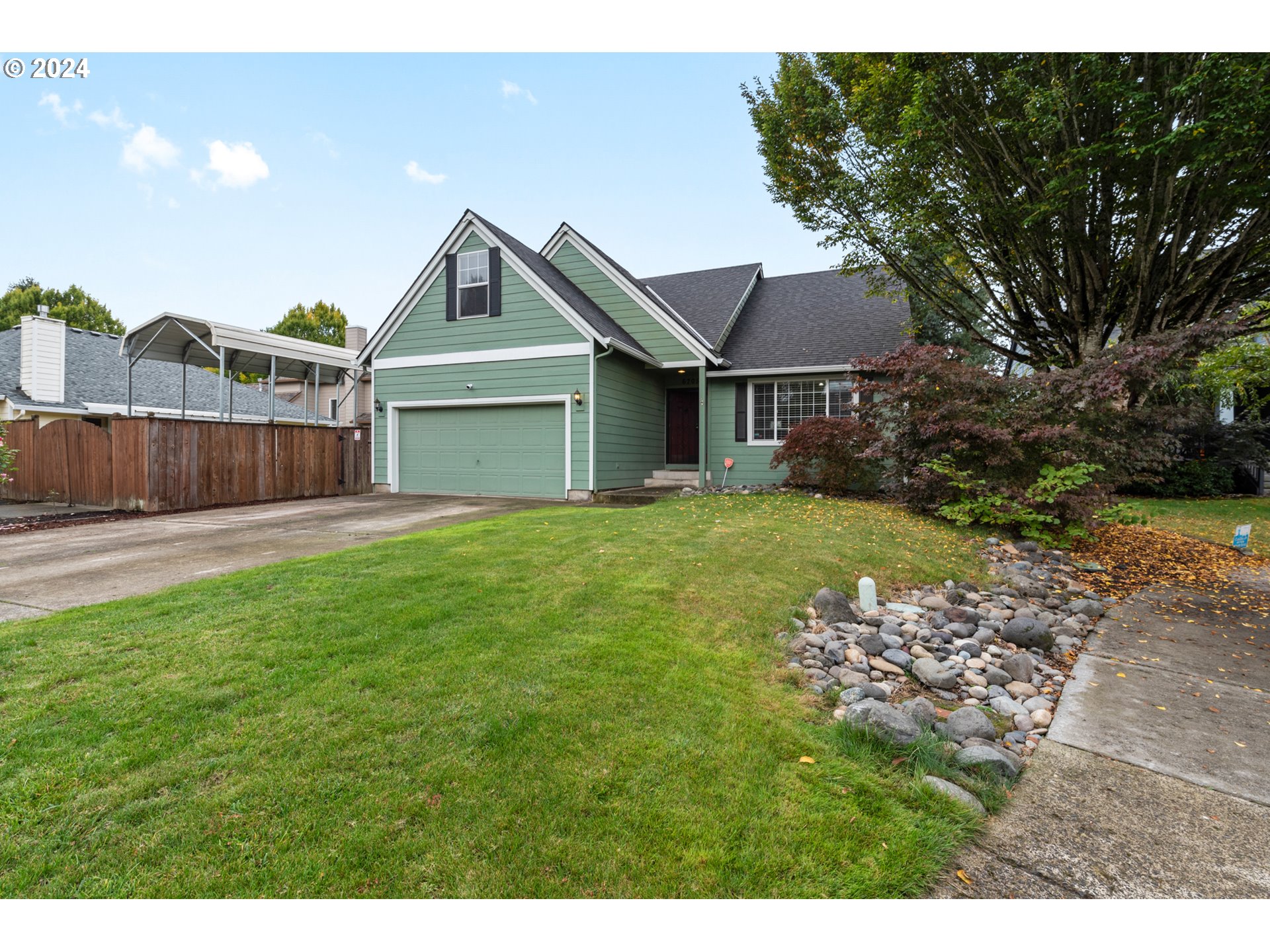 a front view of a house with a yard and fence