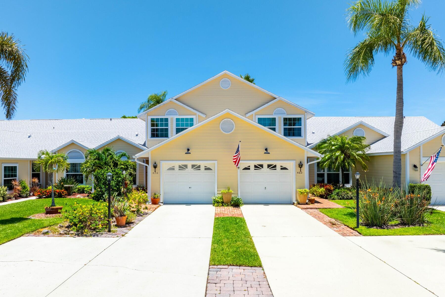 a front view of a house with a yard and potted plants