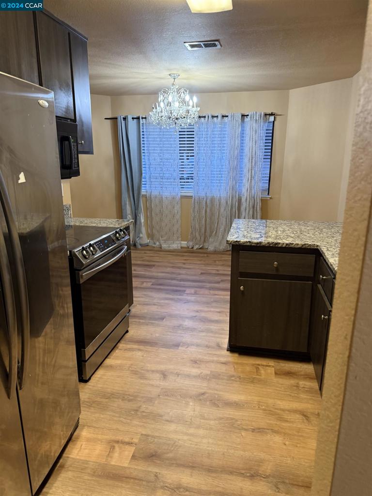 a kitchen with granite countertop a stove and a refrigerator