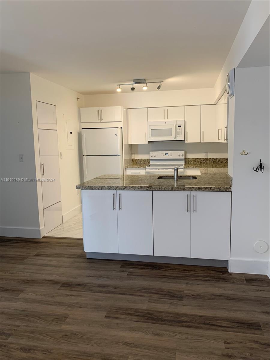 a kitchen with kitchen island white cabinets and sink