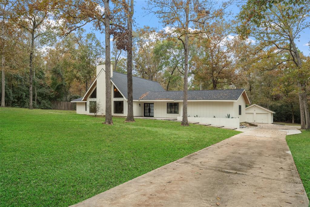 a front view of a house with a yard and trees